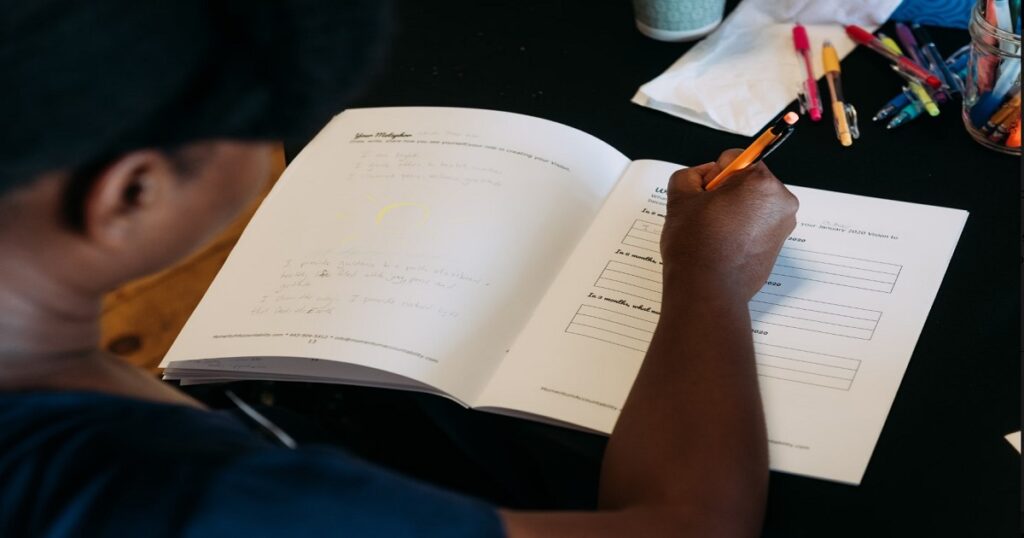 Woman maintaining consistency with business systems using daily planner