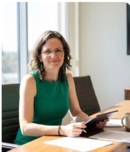 Self-care for women leaders — a professional woman taking a focused moment to review notes and plan her work.