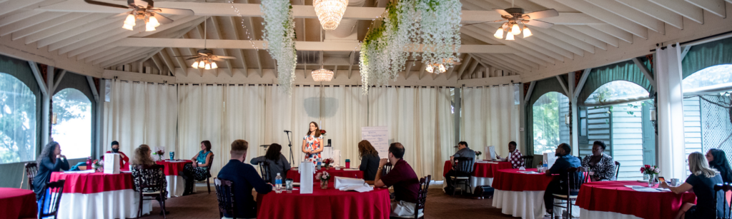 Women leaders building organizations at workshop event with Nettie Owens presenting in elegant venue with small budget setup