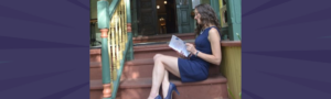 A woman leader sitting alone on steps reading, reflecting the loneliness of being a woman leader