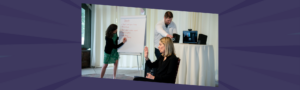 Nettie Owens facilitating a team leadership session at a whiteboard while participants engage actively